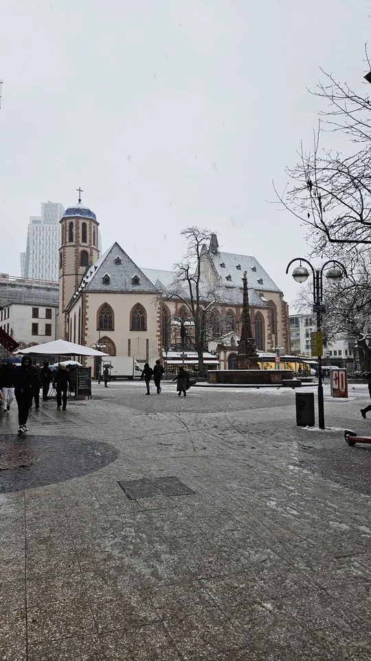 聖母廣場古老教堂與後方現代摩天大樓雪景古今交錯