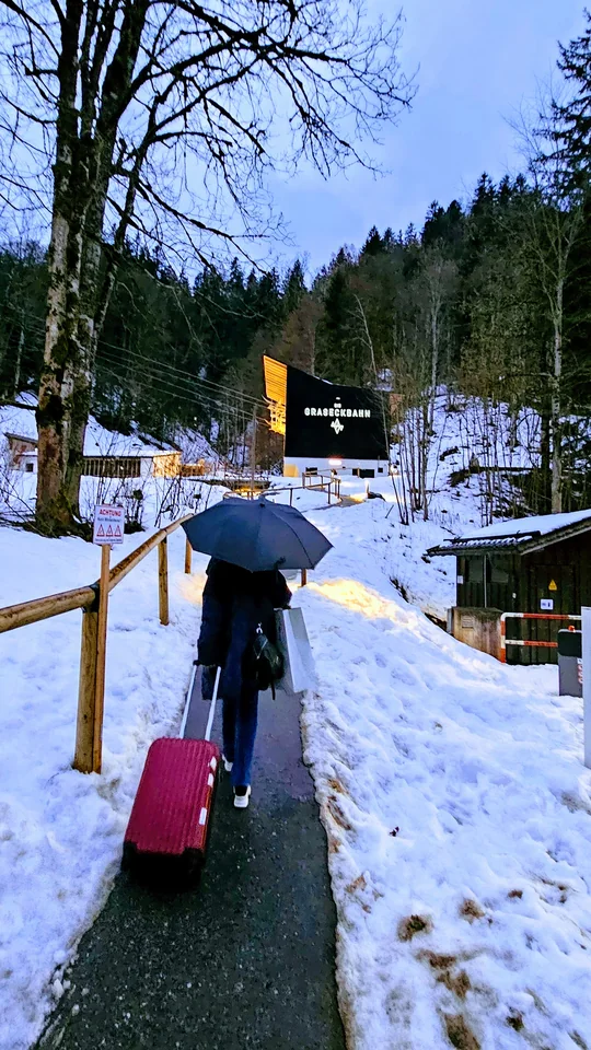 雪道上拖著行李前往 Graseckbahn 纜車站